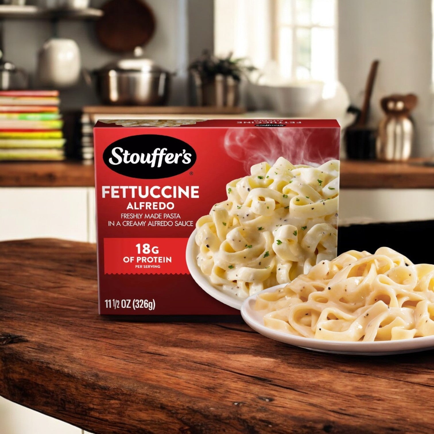 The 11.5 oz. package of Stouffer's Fettuccini Alfredo sits on a wooden counter, offering a quick and easy meal option. A plate of rich, creamy pasta stands out with kitchen items gently blurred in the background.