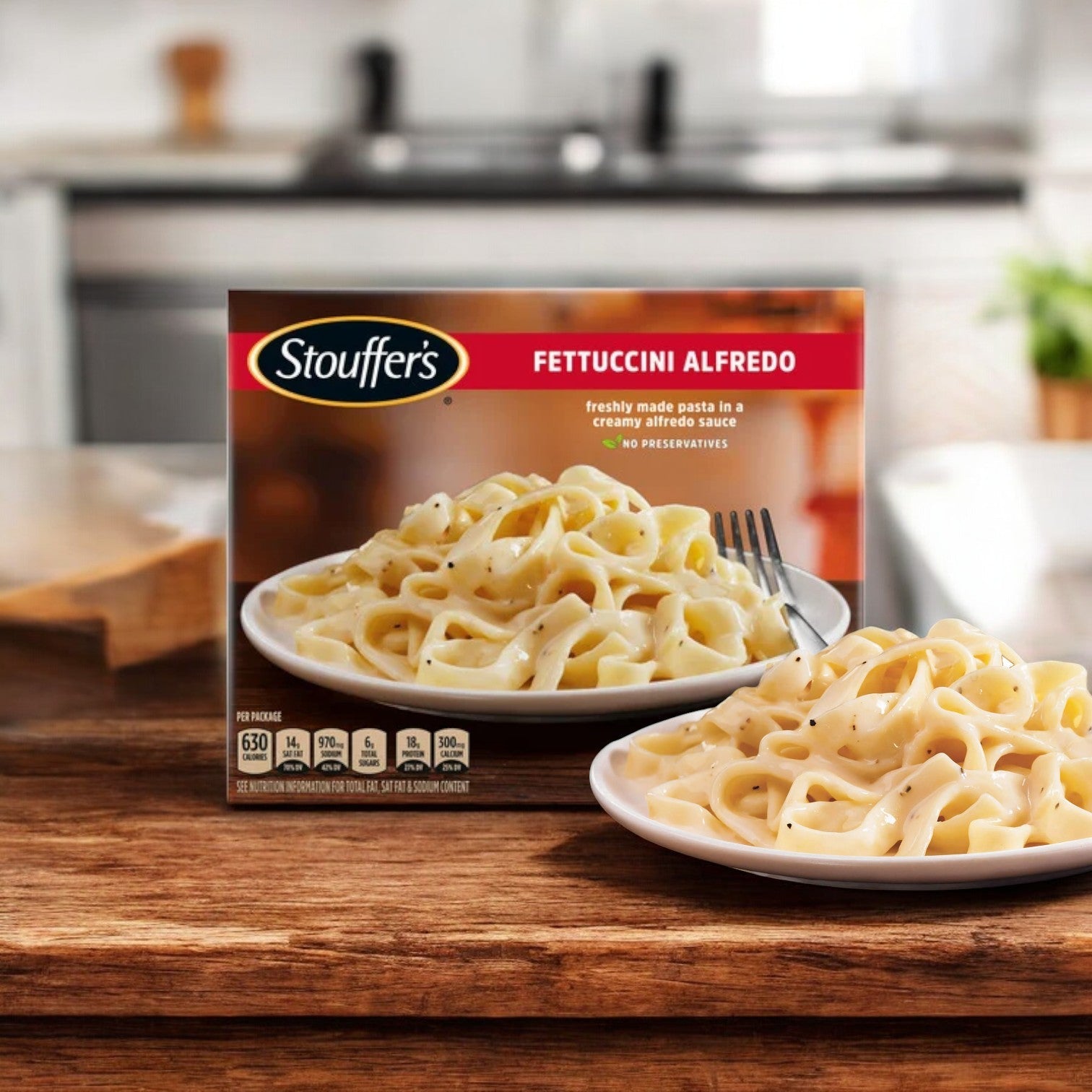 A plate of fettuccini Alfredo is set next to a Stouffer's Bundle! 9 Total! box on the kitchen counter, highlighting easy and comforting meal solutions.