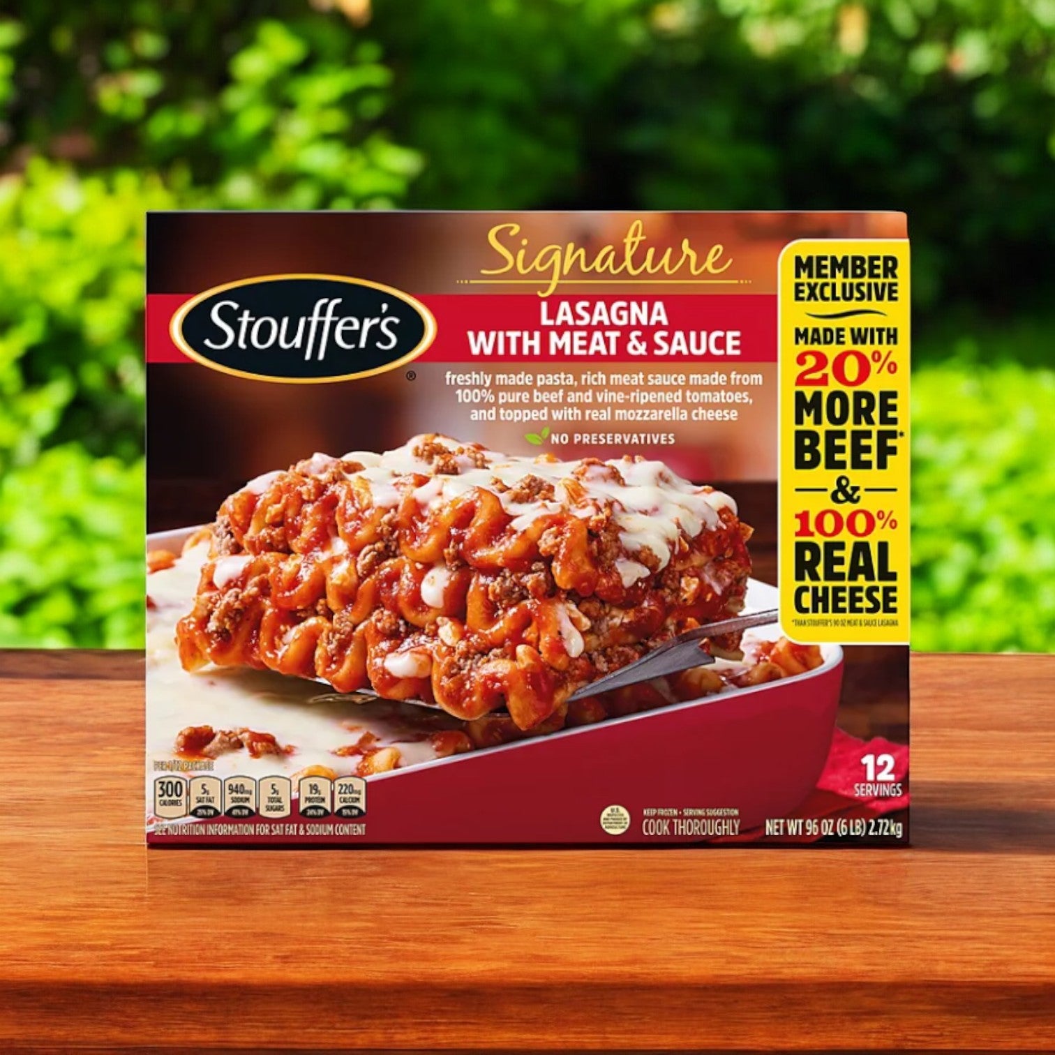Stouffer's Signature Lasagna with Meat Sauce, Frozen 96 oz., sits on a wooden surface, featuring 20% more beef and real cheese. It's an ideal family meal, suggested to be served as a satisfying lasagna slice.