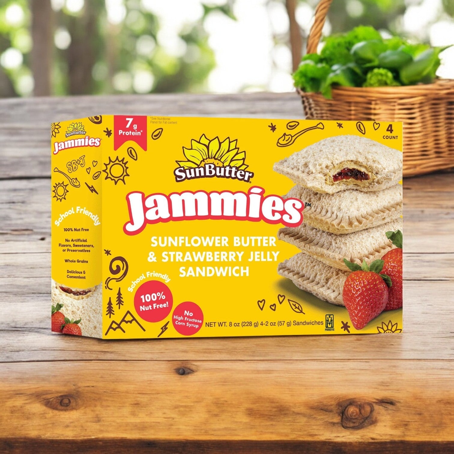 A 4-count box of SunButter Sunflower Butter & Strawberry Jelly Sandwich Jammies, 8 oz., sits on a wooden table with fresh strawberries and greenery, offering a nut-free snack packed with whole grain protein.