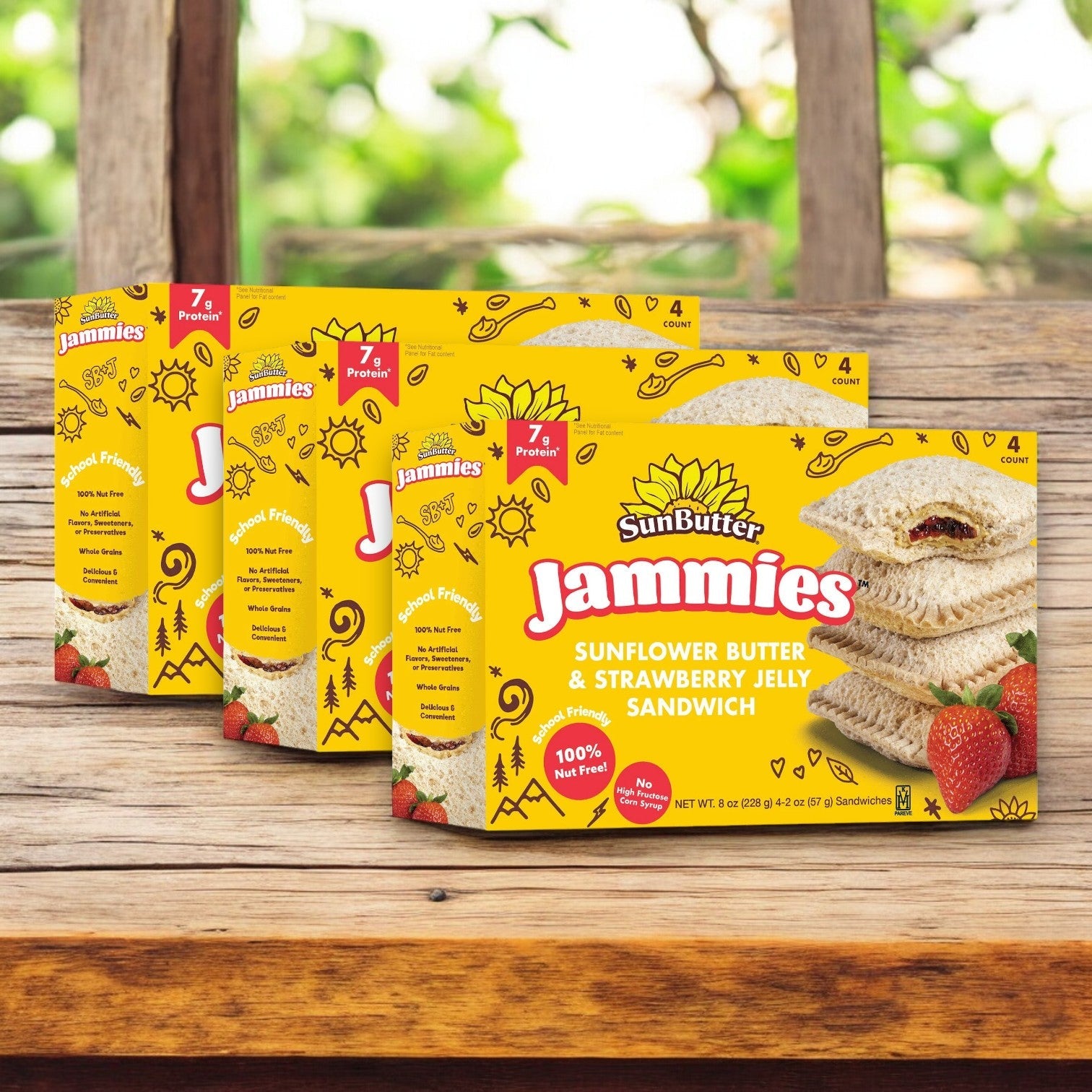Sunbutter Sunflower Butter & Strawberry Jelly Sandwich Jammies, 8 oz. - 12 Count, featuring whole grain bread, rest on wood in bright yellow packaging with sandwich and strawberry illustrations, highlighting their allergy-friendly nature.