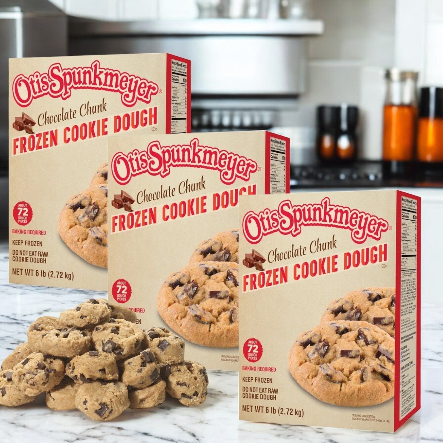 Displayed on the kitchen counter are three boxes of Otis Spunkmeyer Chocolate Chunk Cookie Dough (18 lbs total), alongside an enticing pile of cookie dough pieces. Ideal for bulk baking enthusiasts.