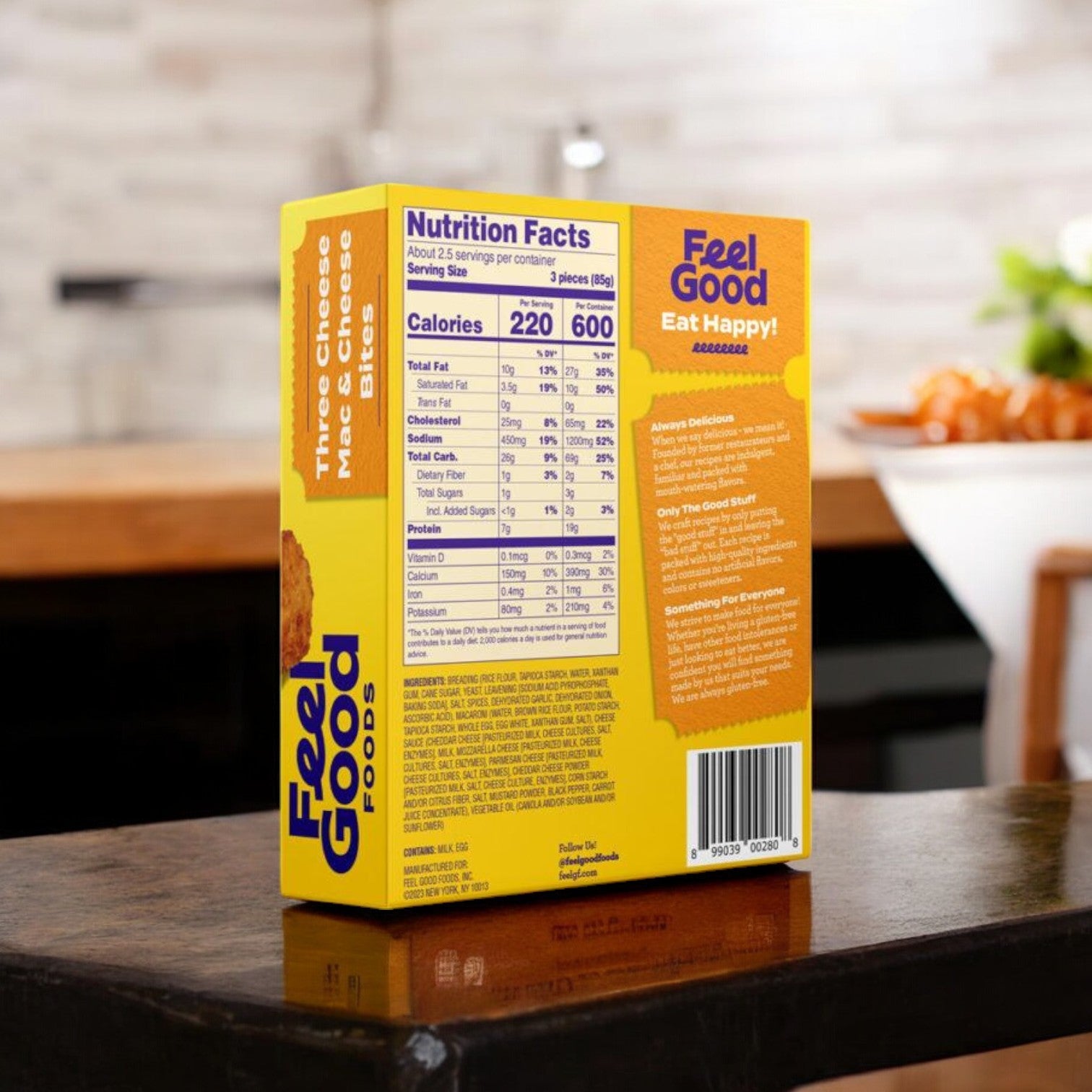 Back of a yellow box labeled "Feel Good Foods Three Cheese Mac & Cheese Bites" highlights gluten-free nutritional information, making it an ideal choice for those seeking a wholesome snack. It sits on a wooden table, enticing you to enjoy its taste and quality.
