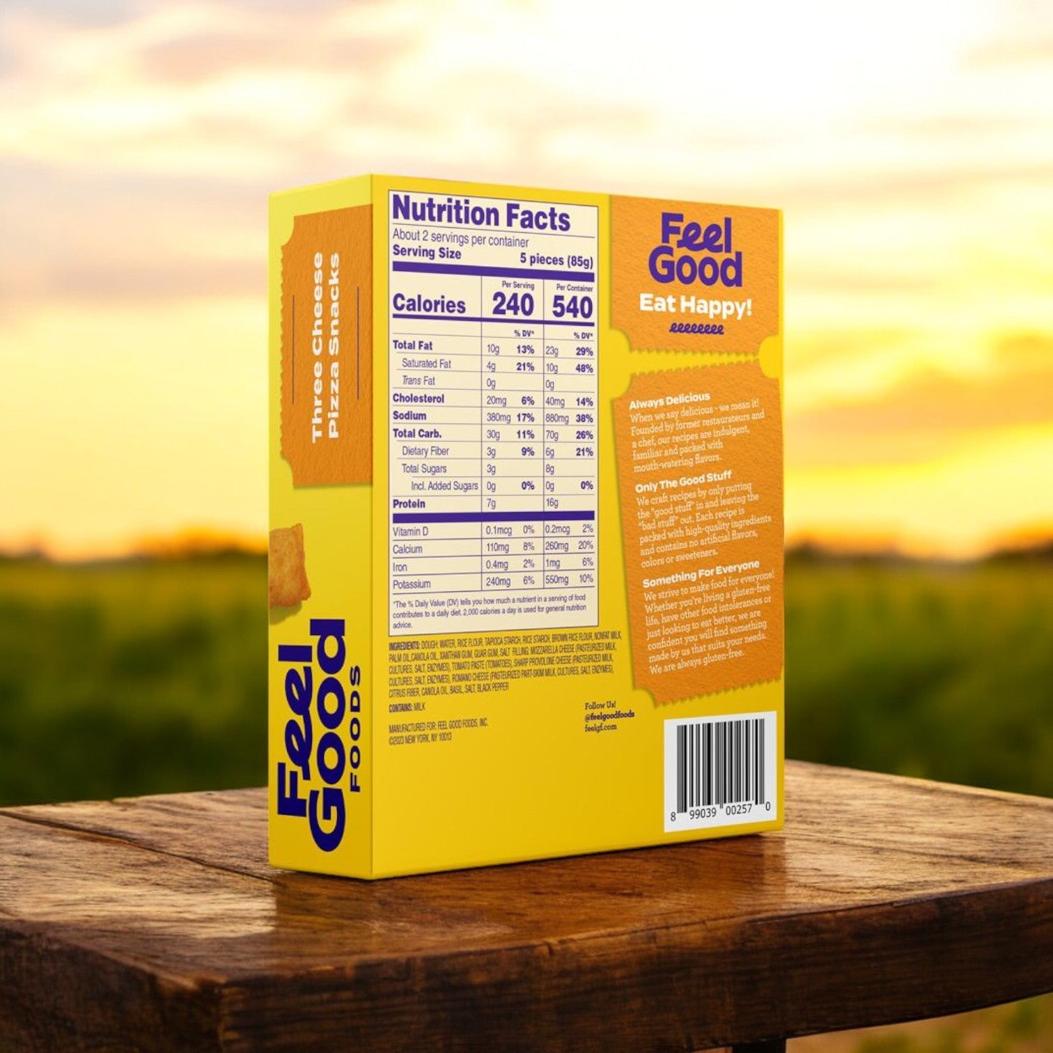 A box from a set of three Feel Good Foods Three Cheese Pizza Snacks, 7 oz., rests on a wooden table, highlighting its gluten-free crust and nutritional information against a blurred outdoor backdrop.