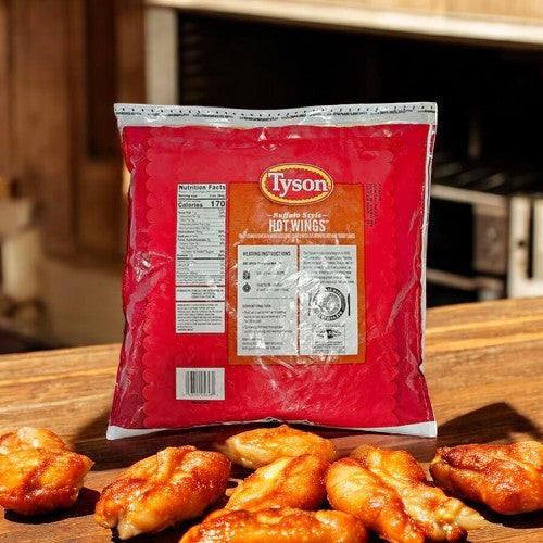 A 4lb bag of Tyson Buffalo Style Hot Wings is on a wooden surface, surrounded by fully cooked chicken wings coated in signature Tyson Buffalo sauce.