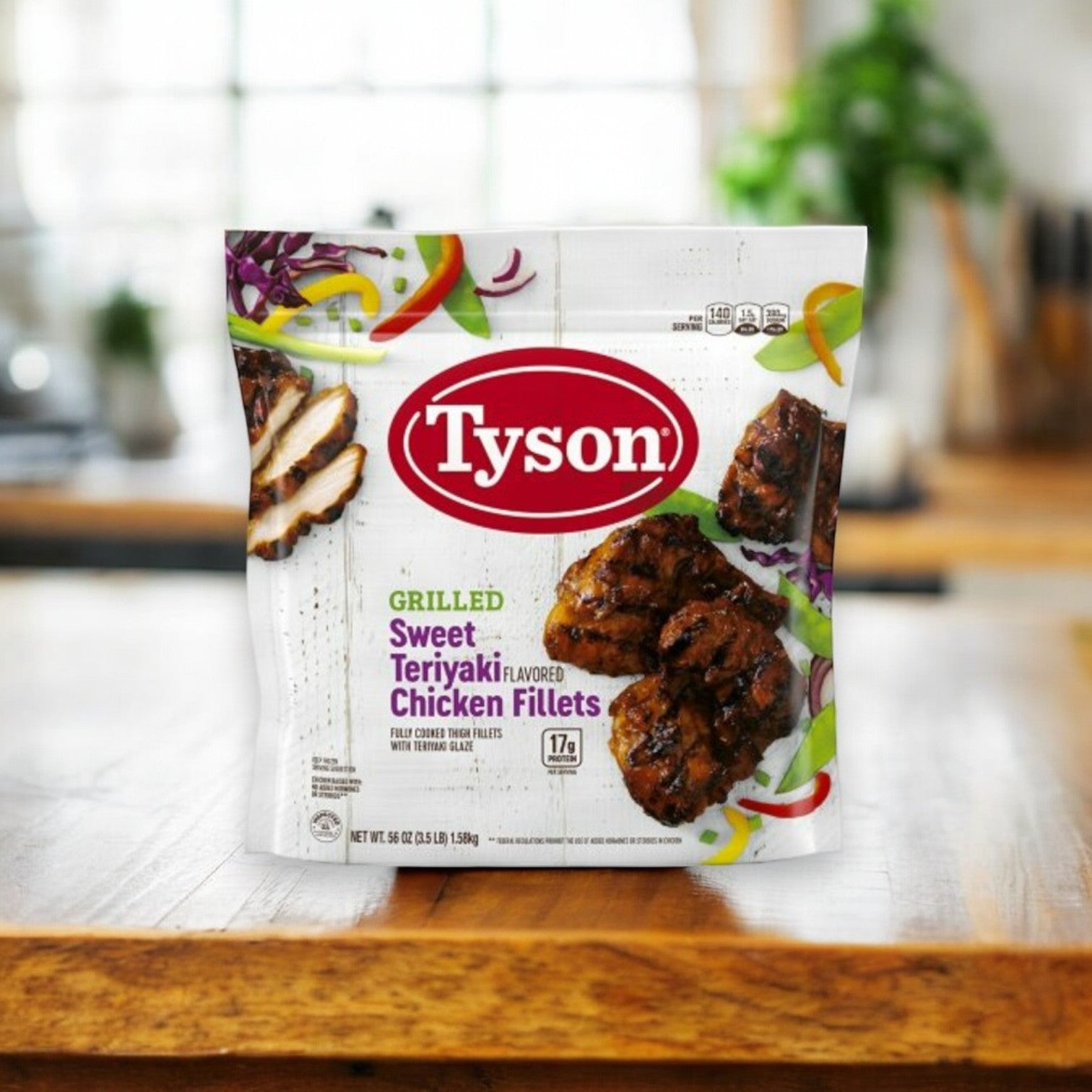 A bag of Tyson Grilled Sweet Teriyaki Flavored Chicken Fillets, weighing 3.5 pounds, rests on a wooden surface in a kitchen setting, poised to introduce Asian-Inspired Cuisine to your dining table.