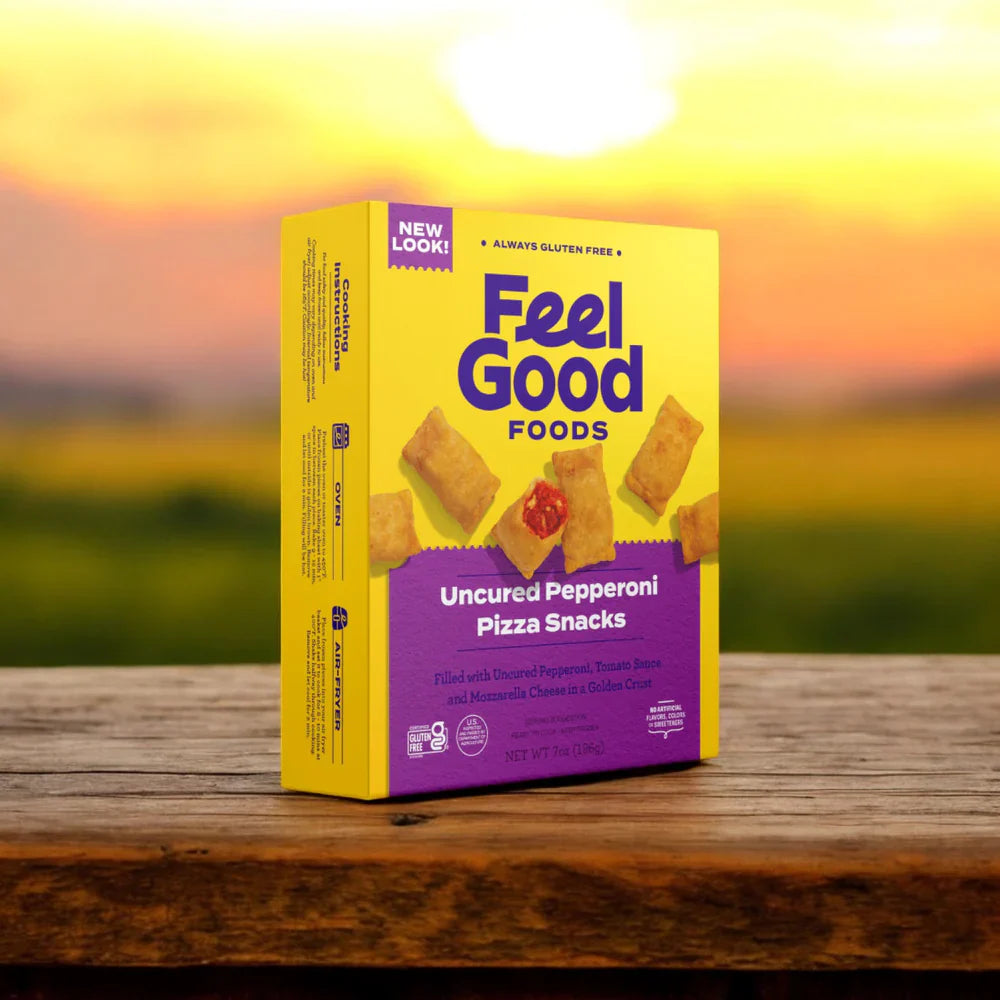 A box from the Feel Good Foods Gluten-Free Bundle, featuring Potstickers, Egg Rolls, and Pizza Snacks, rests on a wooden surface against a sunset. The yellow and purple design highlights its gluten-free promise akin to their tasty potstickers.