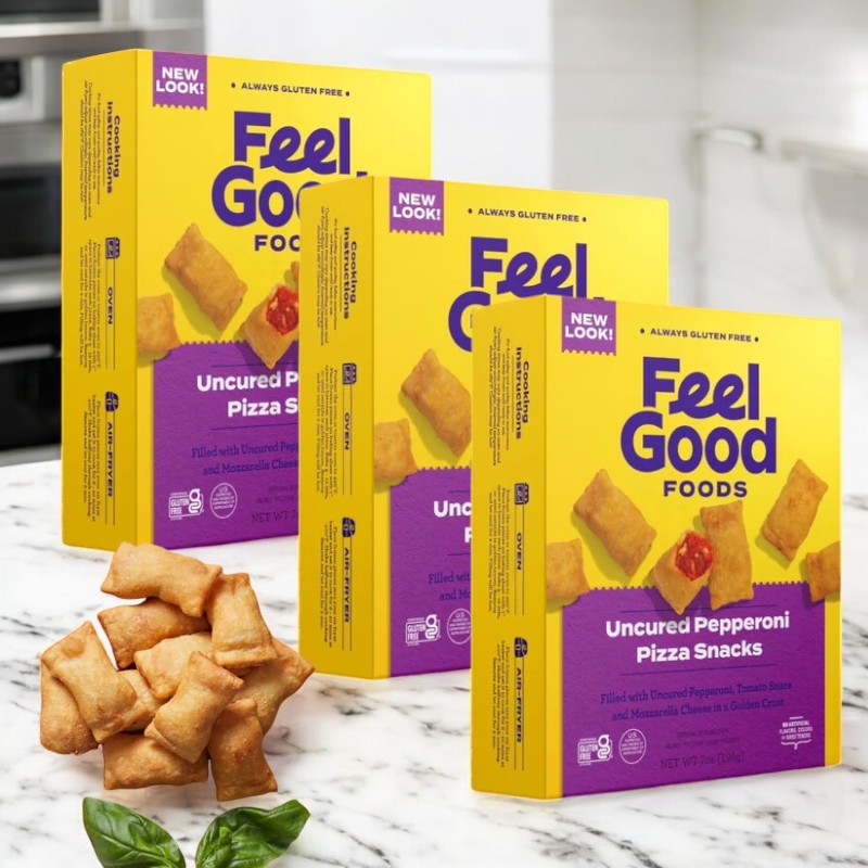 Three boxes of Feel Good Foods Uncured Pepperoni Pizza Snacks with gluten-free crust are displayed on a countertop next to a stack of these savory treats and a basil leaf.