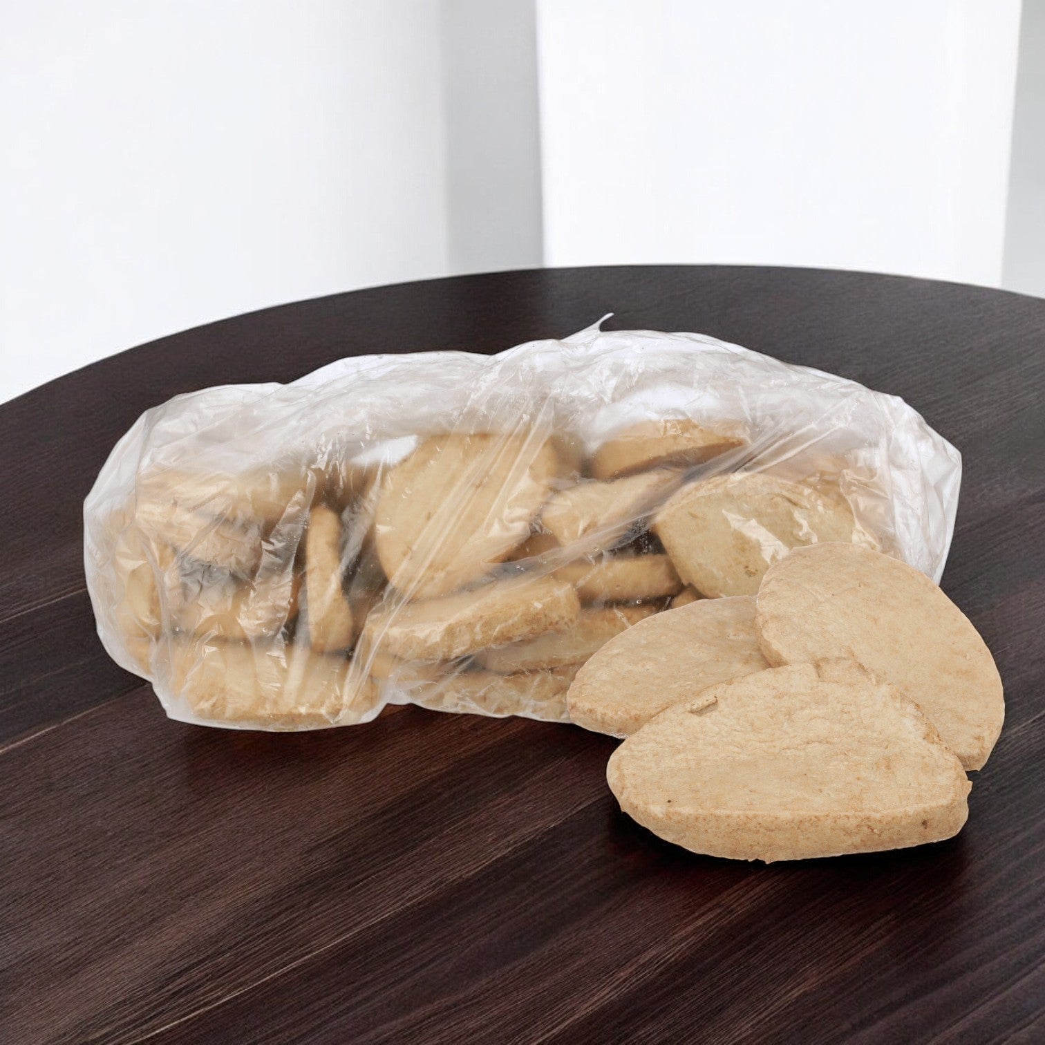 A Gardein box containing 50 veggie burger patties on a dark wooden table, with a few patties outside the box.