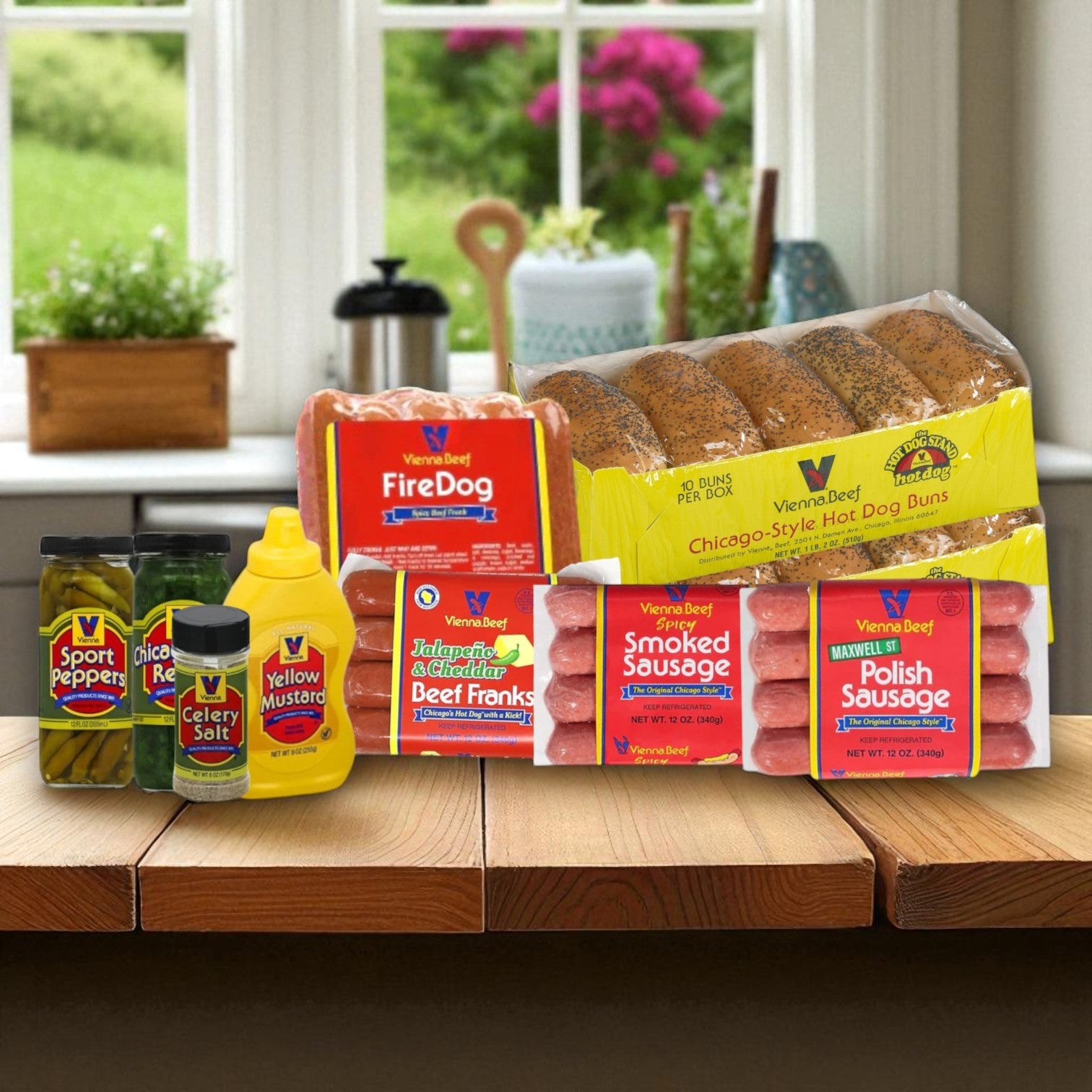 The Vienna Beef Chicago-Style Hot Dog Complete Kit includes hot dogs, Chicago sausage, buns, mustard, relish, celery salt, and sport peppers—all classic toppings—arranged on a wooden table.