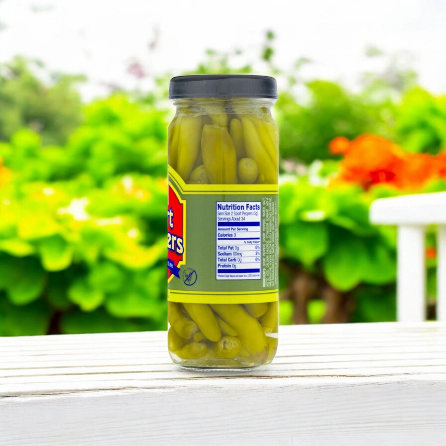 Vienna Sport Peppers 12 oz. by Vienna Beef on a white bench against a blurred garden backdrop.