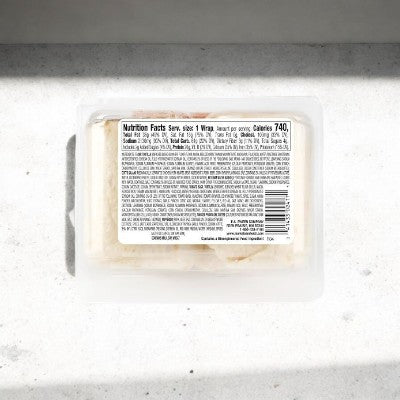 E.A. Sween's Italian Style Wrap, shipped frozen and lasting 30 days in the cooler, is an authentic wrap with genuine Italian ingredients. The plastic container has a nutrition label showing 740 calories and is placed on a light surface.