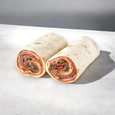 Two E.A. Sween Italian Style Wraps from a 10-count case, cut in half and filled with deli meats and leafy greens, placed on a light-colored surface. Ships frozen; 30-day shelf life once removed from the freezer.