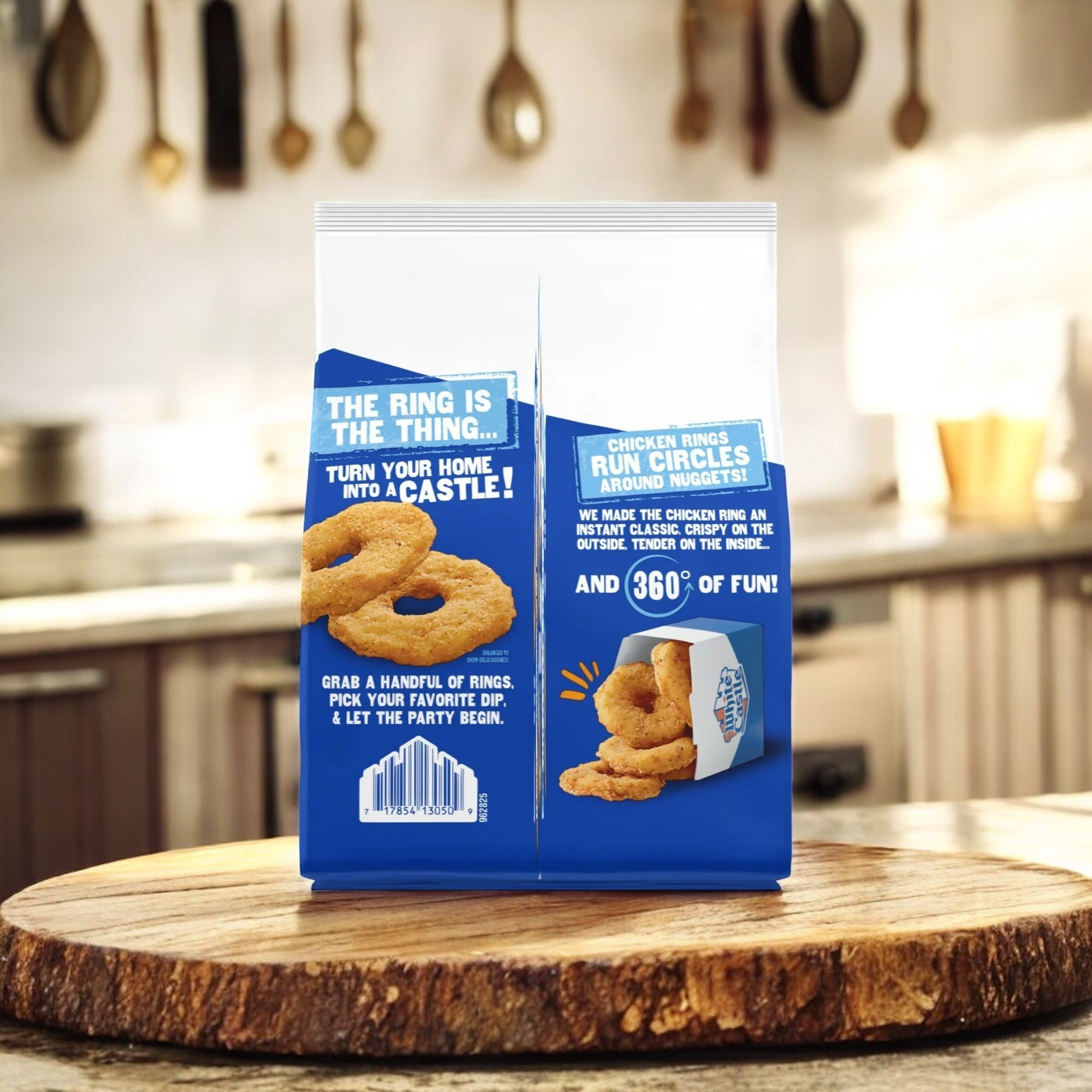 A 20 oz bag of White Castle Spicy Chicken Rings is on a wooden cutting board in a kitchen. The blue packaging displays crunchy, breaded chicken rings and highlights this flavorful snack's fun and versatility.