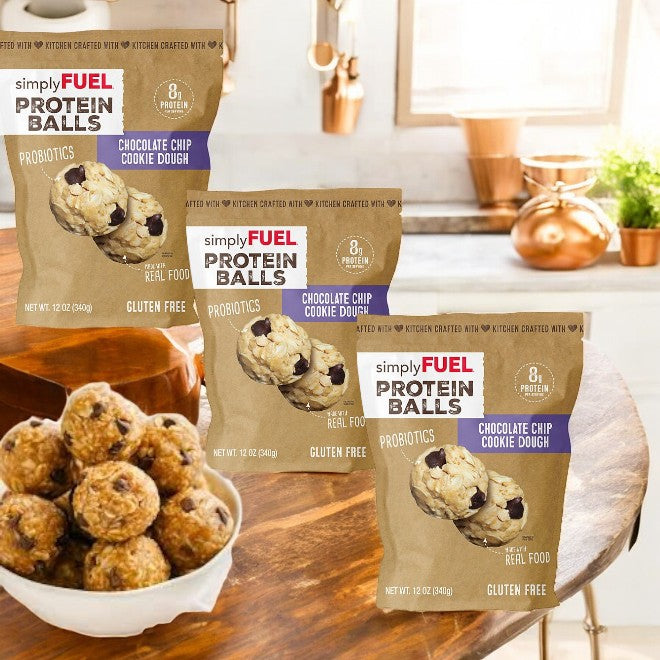 SimplyFUEL Chocolate Chip Cookie Dough Protein Balls by Simple Fuel, enriched with plant-based protein, are showcased on a kitchen counter with a bowl of the flavorful treat in the foreground. The package contains 12 oz and includes 3 counts.