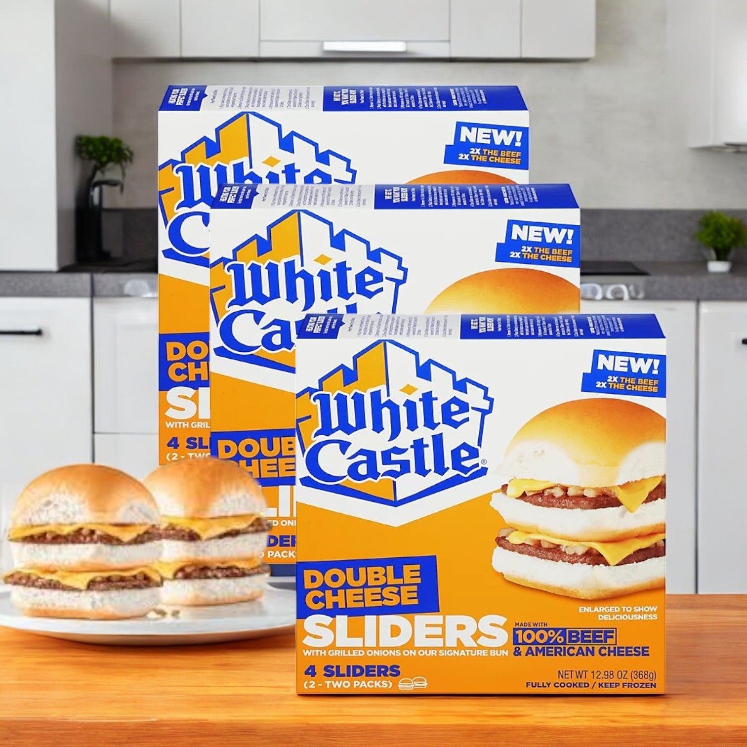 Packages of White Castle Sliders, Double Cheese- 3 Count sit on the counter, showing off their seasoned beef patties in soft, steamed buns. A deliciously assembled slider is on a plate in the foreground, tempting everyone nearby.
