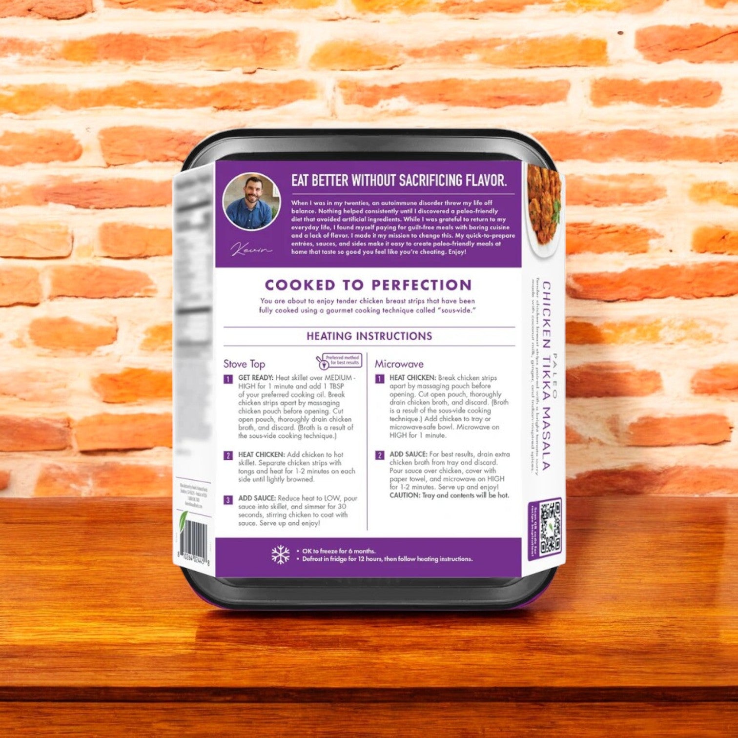A frozen package of Kevin's Chicken Tikka Masala, 16 oz., sits on a wooden surface highlighting the essence of Indian cuisine with heating instructions, an endorsement, and proudly features all-natural ingredients.