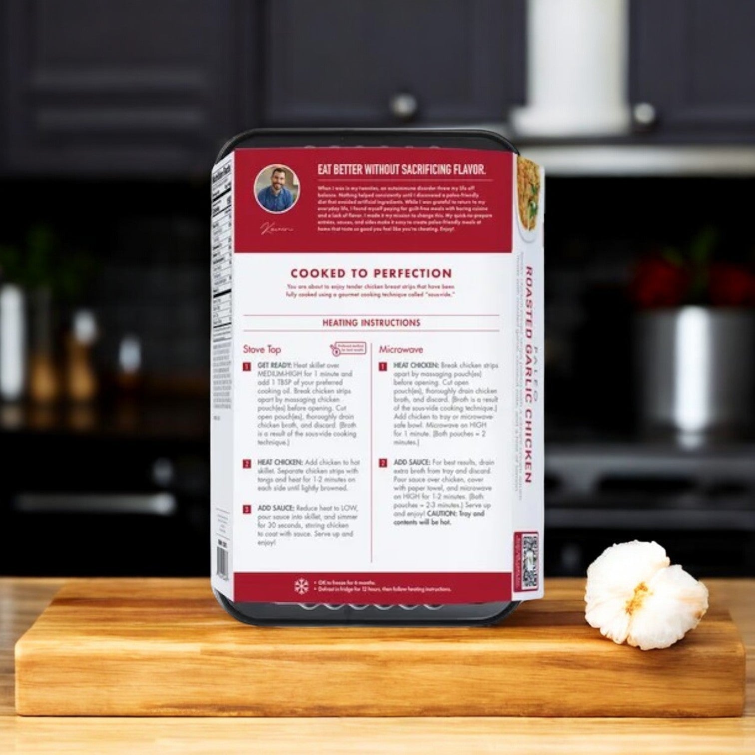 On a wooden kitchen board, Kevin's Natural Foods Roasted Garlic Chicken, 32 oz., displays "Cooked to Perfection" and "Gluten-Free." Heating instructions for stove top and microwave are visible, with a garlic bulb beside it.