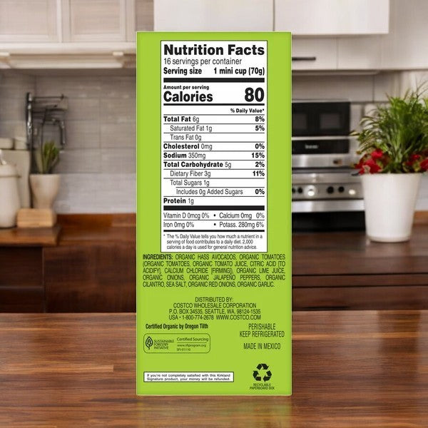 Close-up of a green box for Kirkland Signature Organic Chunky Guacamole, with nutrition facts, ingredients, and recycling info displayed against a kitchen counter background.