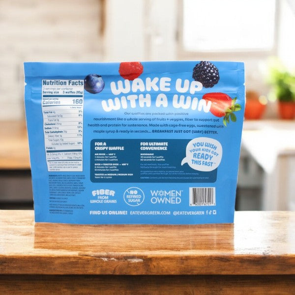 A package of Mixed Berry Cobbler (9 Oz, 3 Count) sits on a kitchen counter, featuring nutritional info and benefits. Pair with Evergreen's Mini Evergreen Waffles for a festive holiday breakfast.