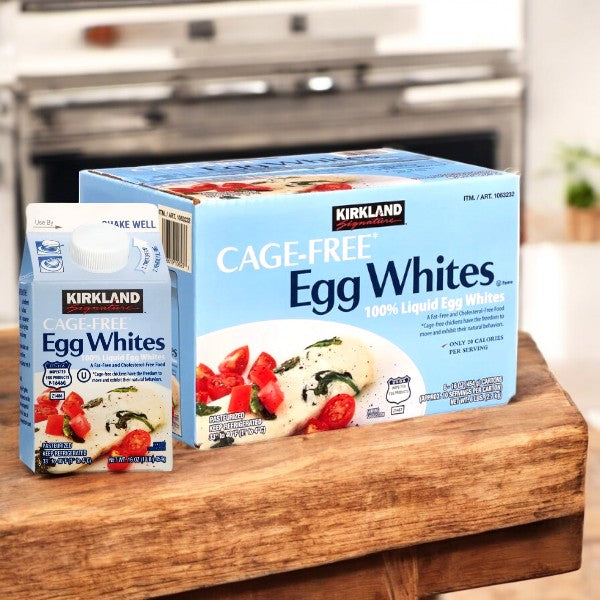 Two cartons of Kirkland Signature Liquid Egg Whites, Cage Free, from a 6-count case, rest on a wooden kitchen surface. One is larger and stands tall while the smaller one sits beside it, both providing a high-protein option for culinary needs.
