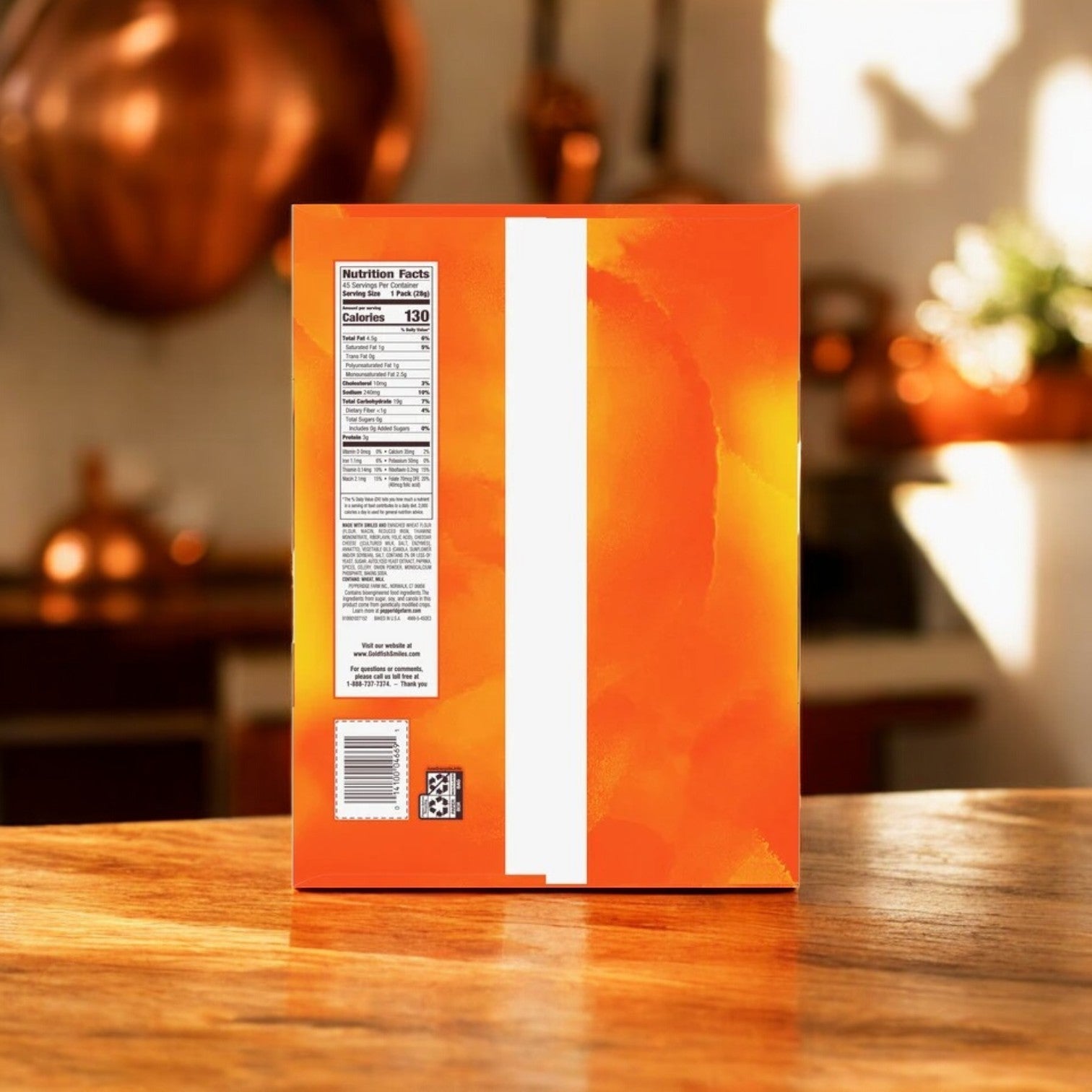 The image features the back of an orange cereal box with visible nutrition facts and a QR code on a wooden counter. Blurred copper kitchenware is in the background, while a cheesy aroma from Pepperidge Farm's Goldfish Baked Snack Crackers, Cheddar, 45-count-1 Pack permeates nearby.