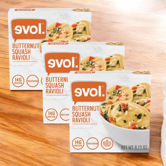 Three boxes of Evol Vegetarian Butternut Squash & Sage Ravioli, 8.13 oz., are on a wooden surface, featuring an image of tasty ravioli with 14g of protein per pack for delicious nutrition.