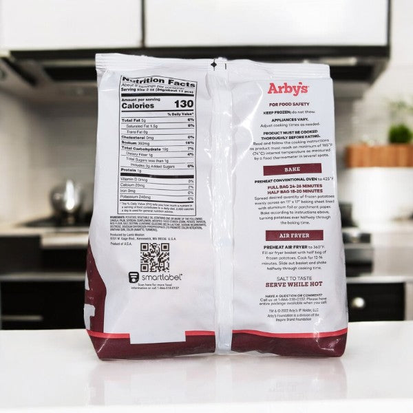 The Arby's Crinkle Fries-26 Oz-1 Count frozen package features nutritional info and cooking instructions amid a kitchen backdrop with a stove and countertop, setting the stage to transform these crispy, golden crinkle-cut fries into a delightful treat.