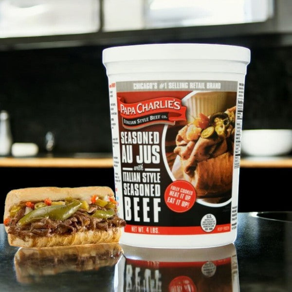 Beside a sandwich, a container of mouthwatering beef and peppers showcases Papa Charlie's Italian Beef. The label reads "Papa Charlie's Seasoned Au Jus with Italian Style Seasoned Beef," promising a savory experience for beef lovers.