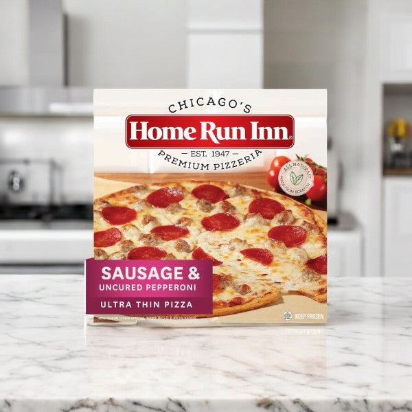 A Home Run Inn Family Sausage and Uncured Pepperoni Pizza, 21.5 oz sits on the kitchen counter in its box.