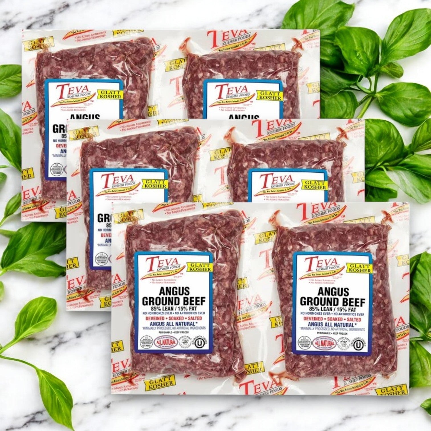 Teva Kosher Foods Glatt Kosher Angus Ground Beef, 85% lean, is attractively displayed on marble with fresh basil leaves.