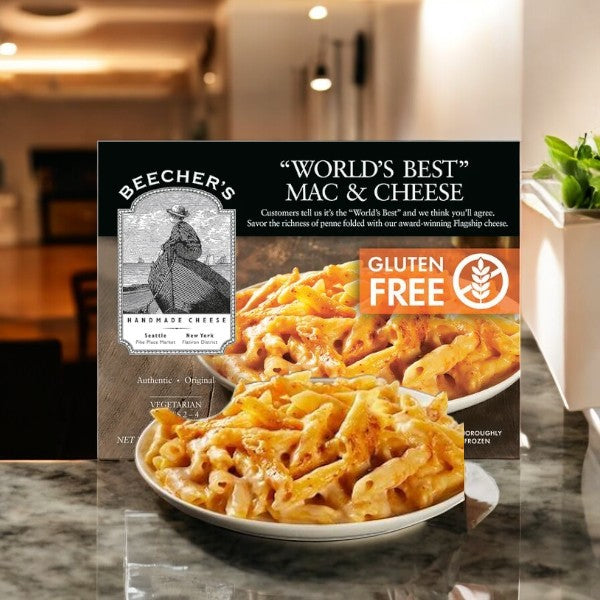 An 18oz box of Beecher's Handmade Cheese Gluten Free "World's Best" Mac & Cheese is on a table, featuring packaging that displays cheesy pasta in a bowl, epitomizing premium comfort food.