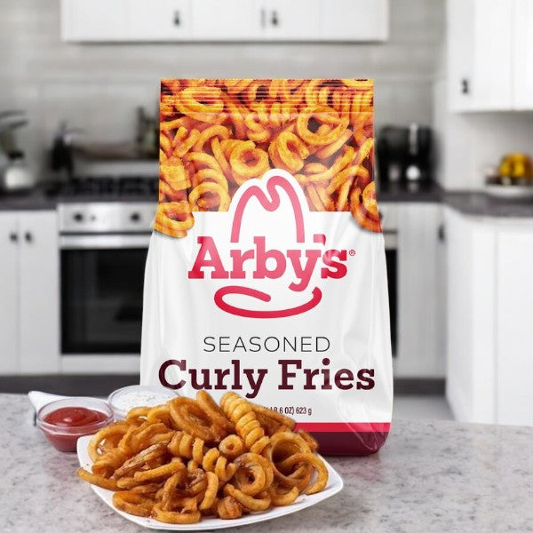 A bag of Arby's Curly Fries, Seasoned - 1 Count, tempts from the kitchen counter, promising a crispy snack. Nearby, a plate of these iconic fries sits enticingly with two dipping sauces.