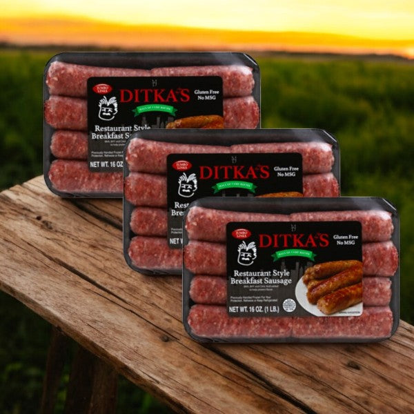 Three packages of Vienna Beef's Ditka’s Breakfast Sausage, Restaurant Style (16 oz.), rest on a wooden surface against a backdrop of a field and sunset, highlighting their exquisite appeal.