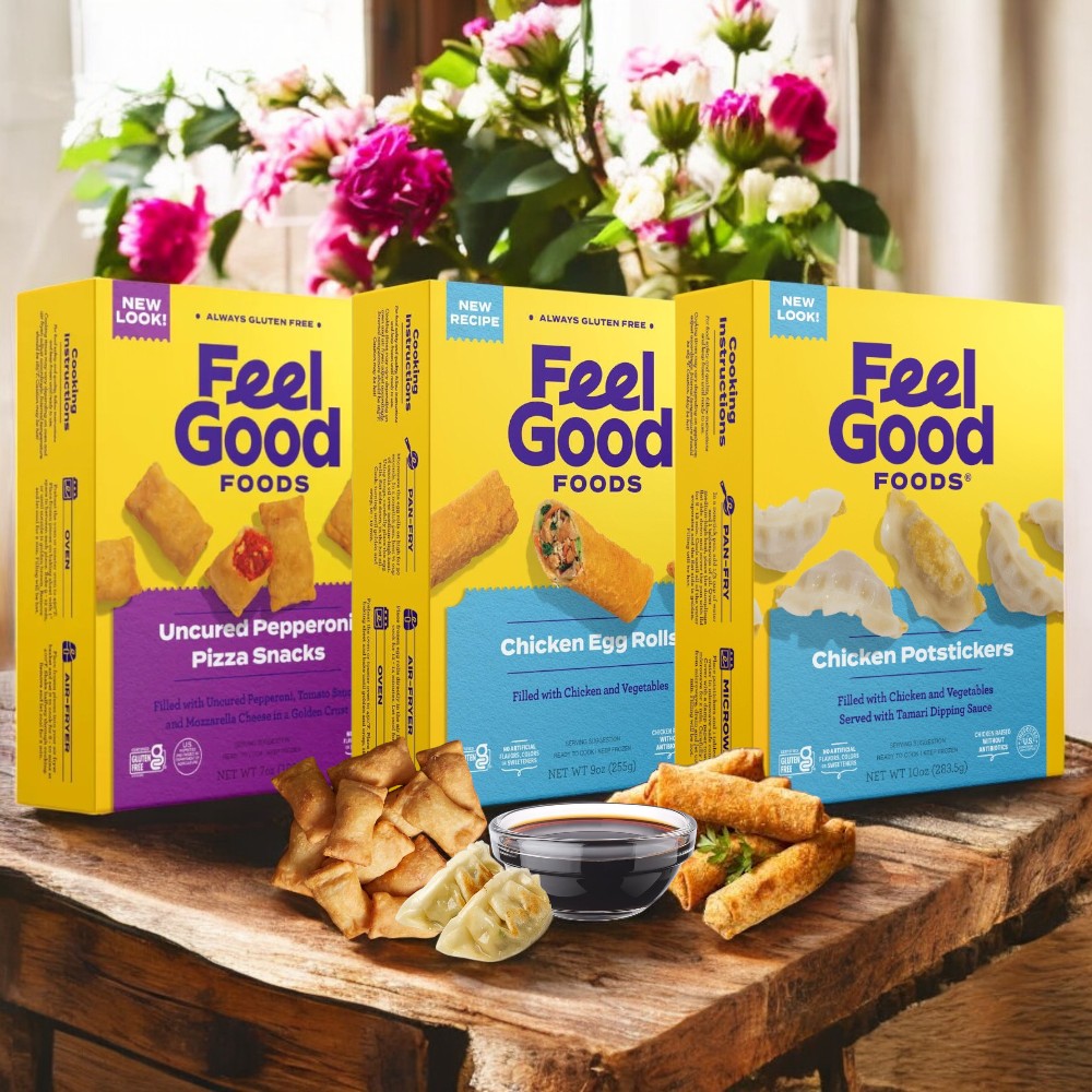 Feel Good Foods Gluten-Free Bundle, featuring Uncured Pepperoni Pizza Snacks, Chicken Egg Rolls, and Chicken Potstickers, is artfully arranged on a wooden table with flowers in the background.