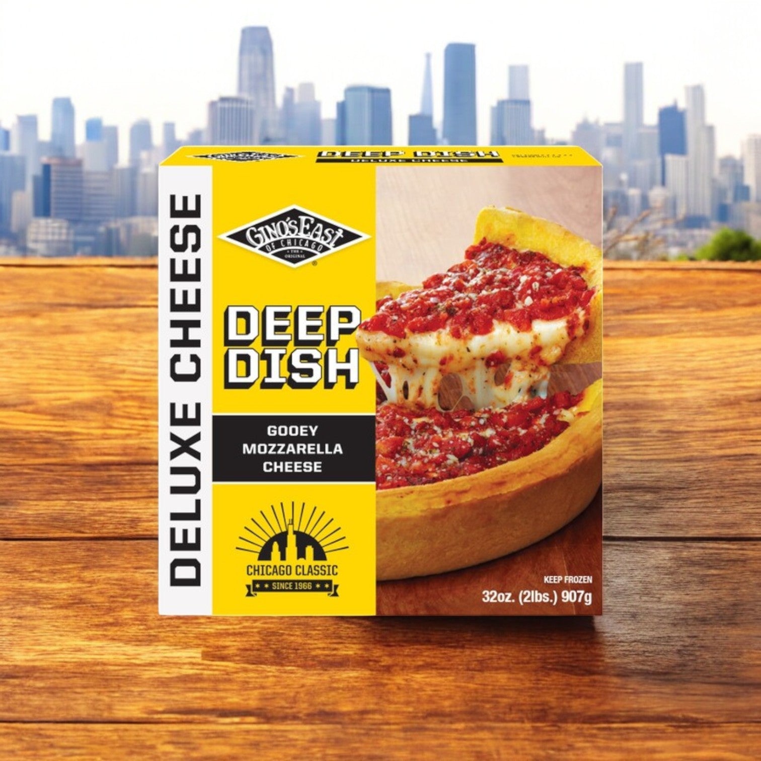 A Gino's East and Frango Mints! 3 Pack Combo box lies on a wooden surface with the city skyline in the background. It showcases a delicious slice of Chicago deep-dish pizza, embodying the classic essence of Gino's East Pizza in every detail.
