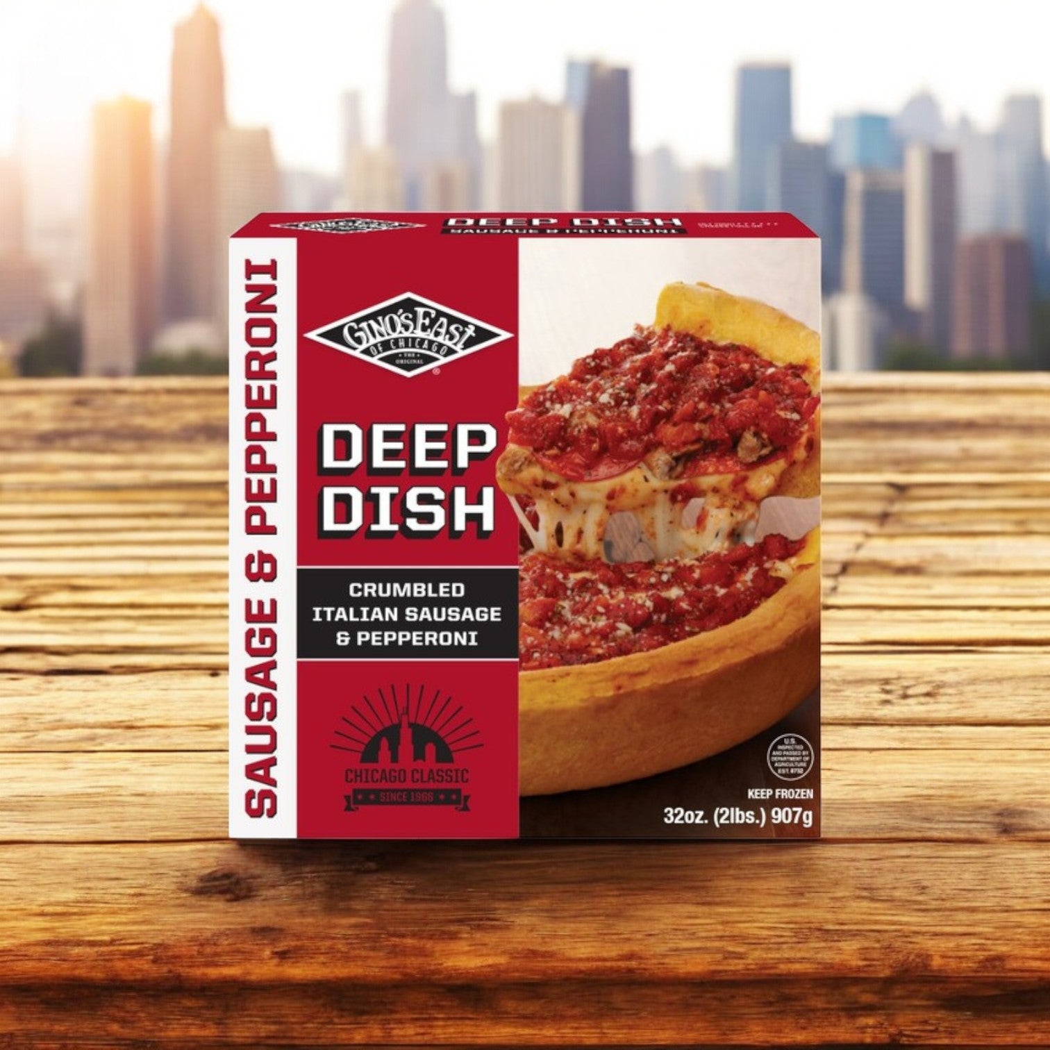 A Gino's East Pizza box with Italian sausage and pepperoni atop a wooden surface displays the iconic Chicago deep-dish pizza image.