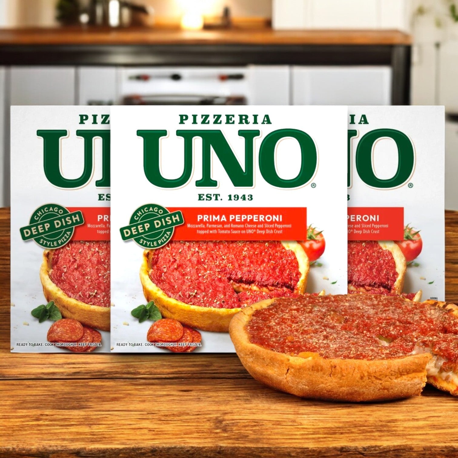 Three boxes of Pizzeria Uno 9in Chicago Style Deep Dish Prima Pepperoni Pizza, Tomato Sauce, 27.3 oz., are displayed with one cooked pizza cut open in front on a wooden kitchen counter.
