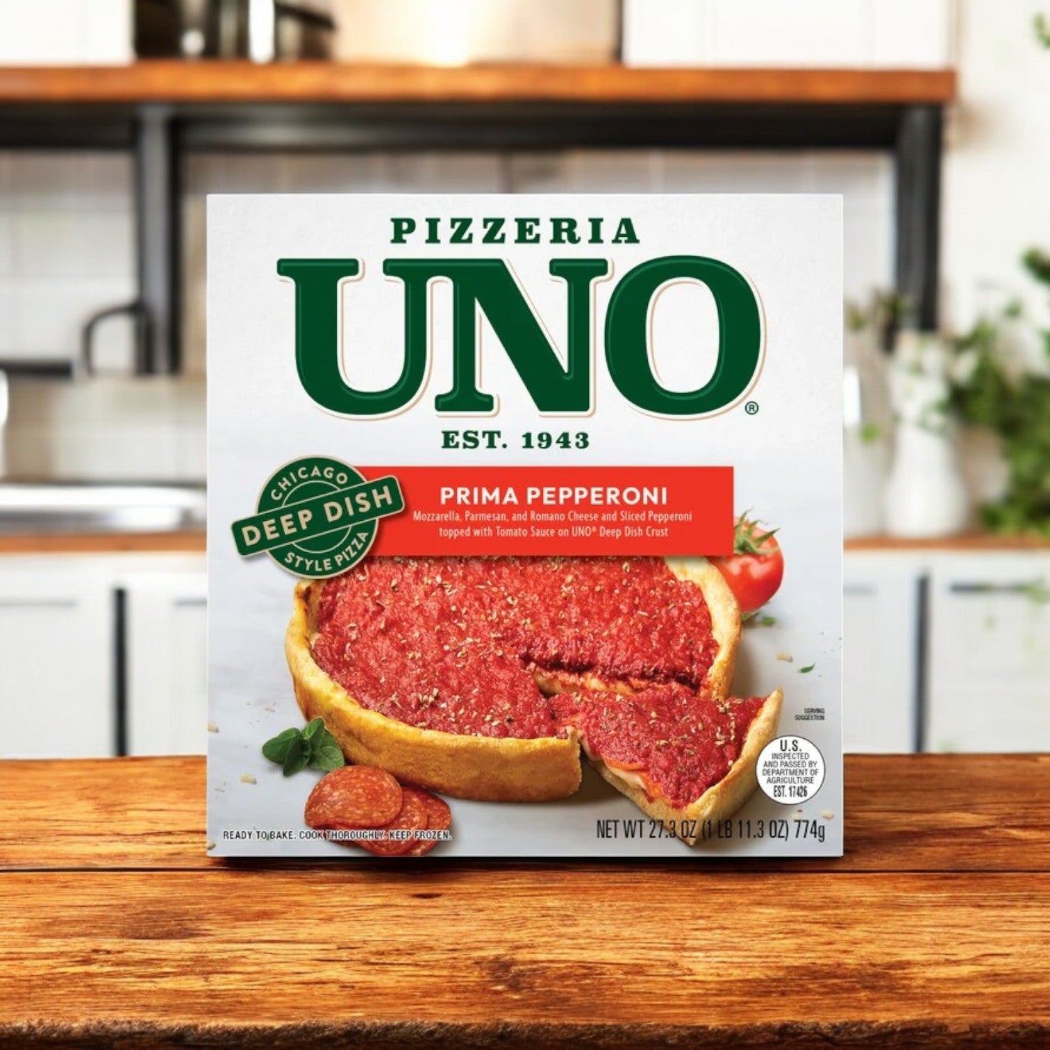 A box of Pizzeria Uno 9in Chicago Style Deep Dish Prima Pepperoni Pizza, Tomato Sauce, 27.3 oz., rests invitingly on a wooden kitchen counter, highlighting the rich flavors of a Chicago Deep Dish Pizza.