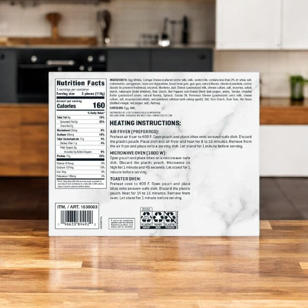 On a kitchen counter, the back of a packaged food box shows nutrition facts, ingredients, and heating instructions for air fryer, microwave, and toaster oven. Ideal for fans of Kirkland Signature Egg White with Cheese Trio and Peppers Egg Bites seeking a quick gourmet delight.