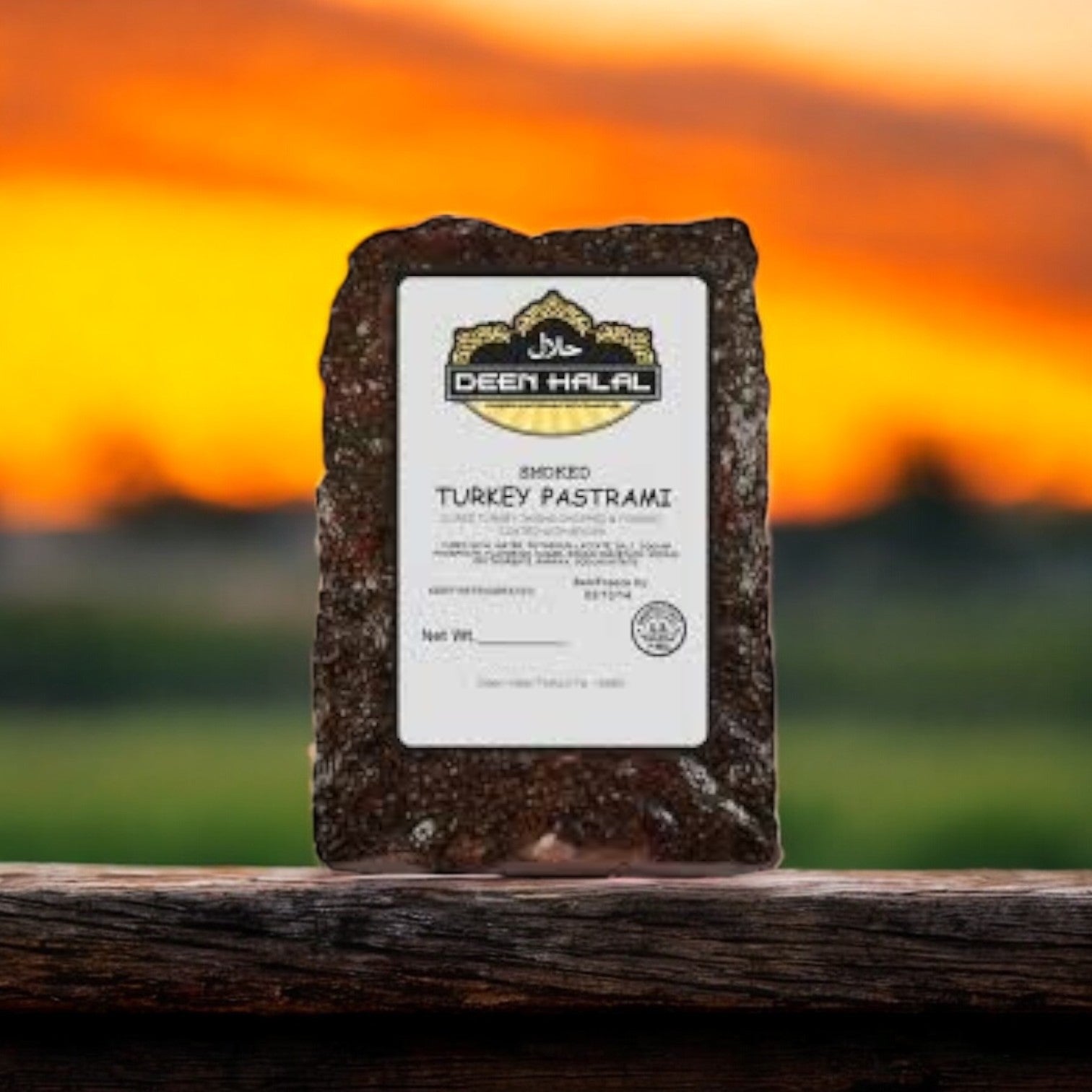 A 4.0 lb Deen Halal Turkey Pastrami slab lies on a wooden surface, accentuated by the vibrant orange sunset sky in the background.