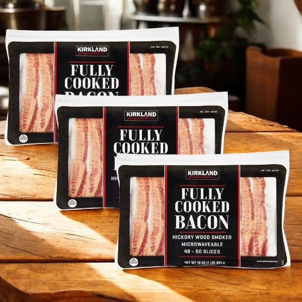 Three packs of Kirkland Signature Fully-Cooked Bacon, Hickory Wood Smoked, are displayed on a wooden surface, emphasizing their microwaveable convenience and savory flavor.