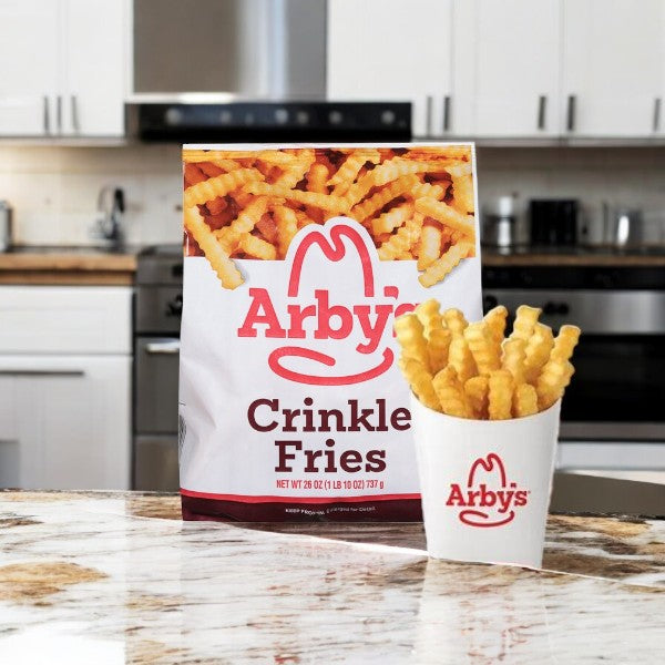 Arby's Crinkle Fries-26 Oz, featuring their crispy golden and signature crinkle-cut design, are invitingly displayed in a bag and cup on a kitchen counter, framed by the stove and gleaming white cabinets.