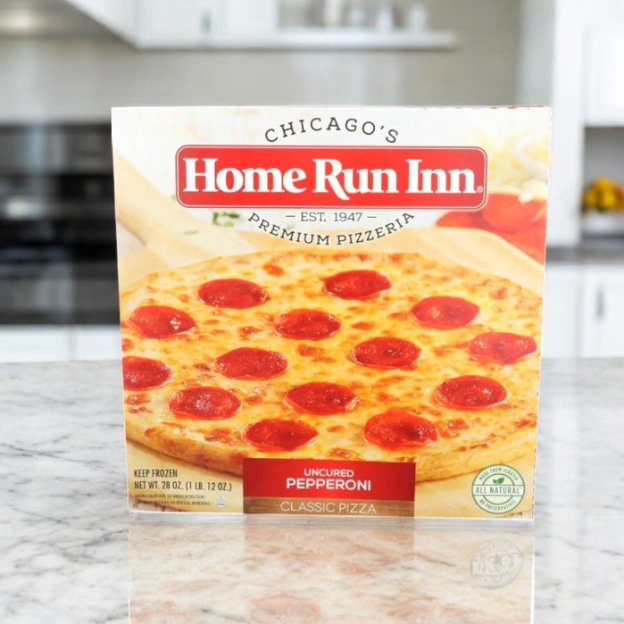 The "Home Run Inn Pepperoni Classic Pizza, 28 oz." box graces the kitchen countertop, featuring a buttery flaky crust topped with 100% real mozzarella cheese.