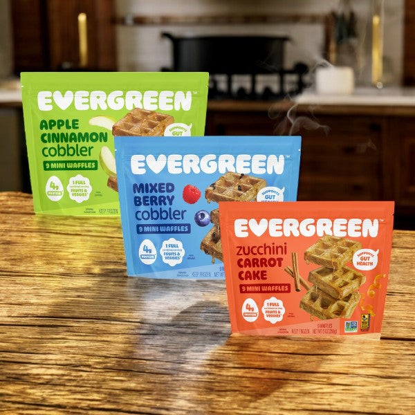 Evergreen 3-Pack Combo – Mini Waffles Variety Pack, featuring Apple Cinnamon Cobbler, Mixed Berry Cobbler, and Zucchini Carrot Cake flavors, is displayed upright on a kitchen counter.