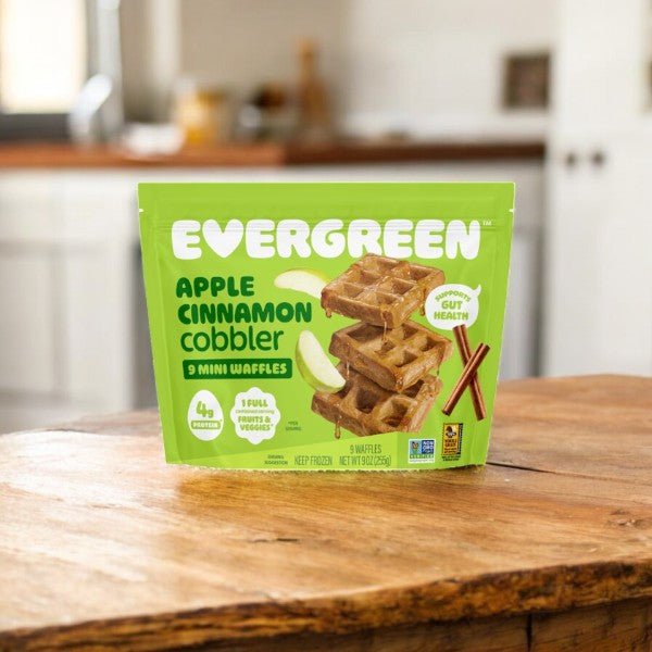 A pack of Evergreen 3-Pack Combo – Mini Waffles Variety Pack rests on a wooden counter in a cozy kitchen.