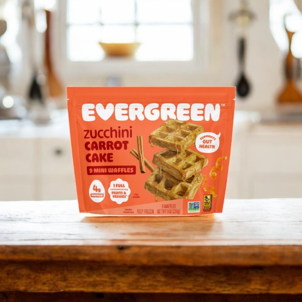 An Evergreen 3-Pack Combo – Mini Waffles Variety Pack is displayed on a wooden table in a bright kitchen setting.