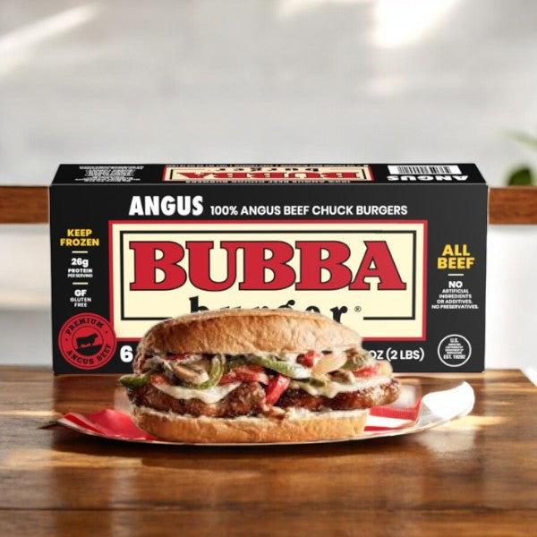 An Angus beef sandwich with cheese and vegetables sits before a Bubba Burger Burgers, Angus Beef-1 Count package on a wooden surface, showcasing its premium flavor.
