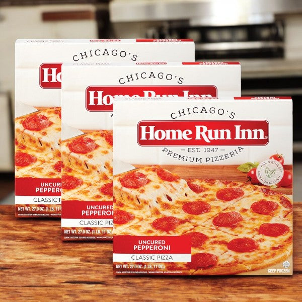 Three boxes of Home Run Inn Classic Pizza, Uncured Pepperoni, 27 oz. (3 total pizzas) from Home Run Inn are displayed on a kitchen counter.