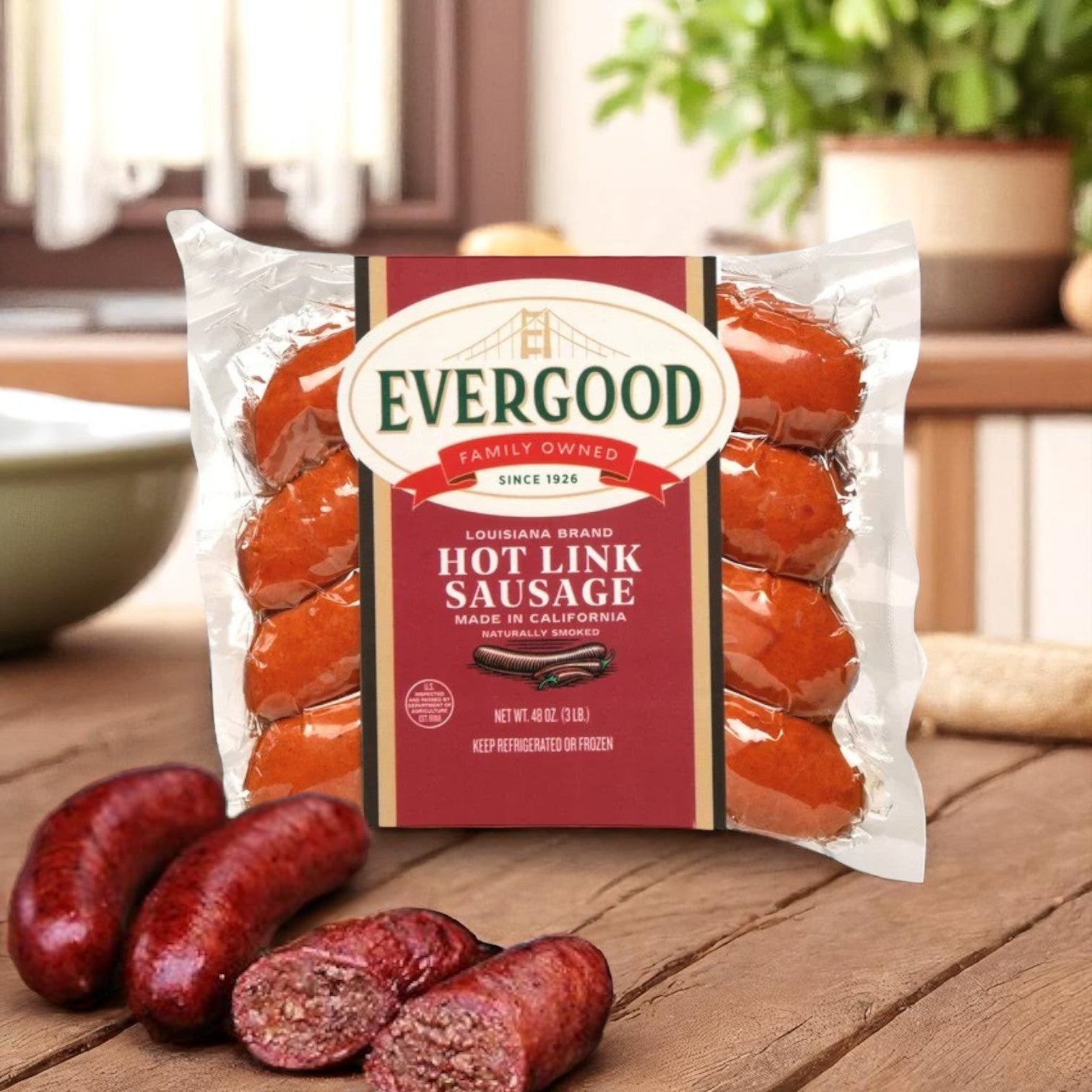 A 3-lb pack of Evergood Louisiana Brand Hot Link Sausage (12 links) sits on a wooden table with sliced pieces in front, kitchen background visible.